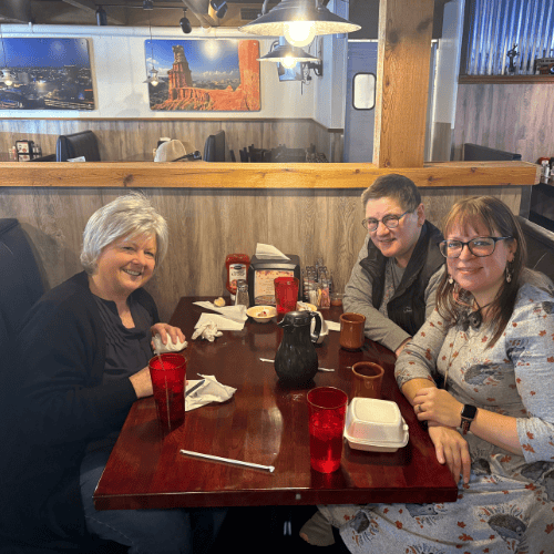 Sarah Wildey, right front, Tina Carpenter, right back, and Kathy Kendle, left, sitting around a table.